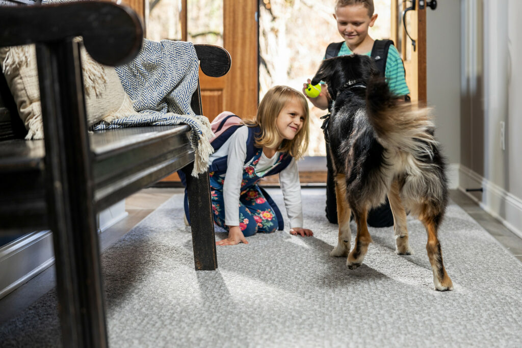 Kids playing with dog on carpet floor | Thornton Flooring